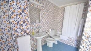 A bathroom with patterned wallpaper, a sink, a toilet, and a bidet. - Hostal On Dormire (Valencia)