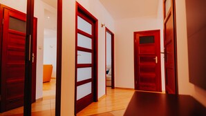 A hallway with wooden doors and a tiled floor. - Elite Apartments Jelitkowski Dwor (Gdansk)