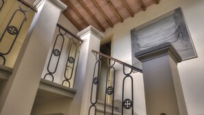 A staircase with ornate metal railings and a wooden ceiling. - Albergo San Lorenzo (Poppi)