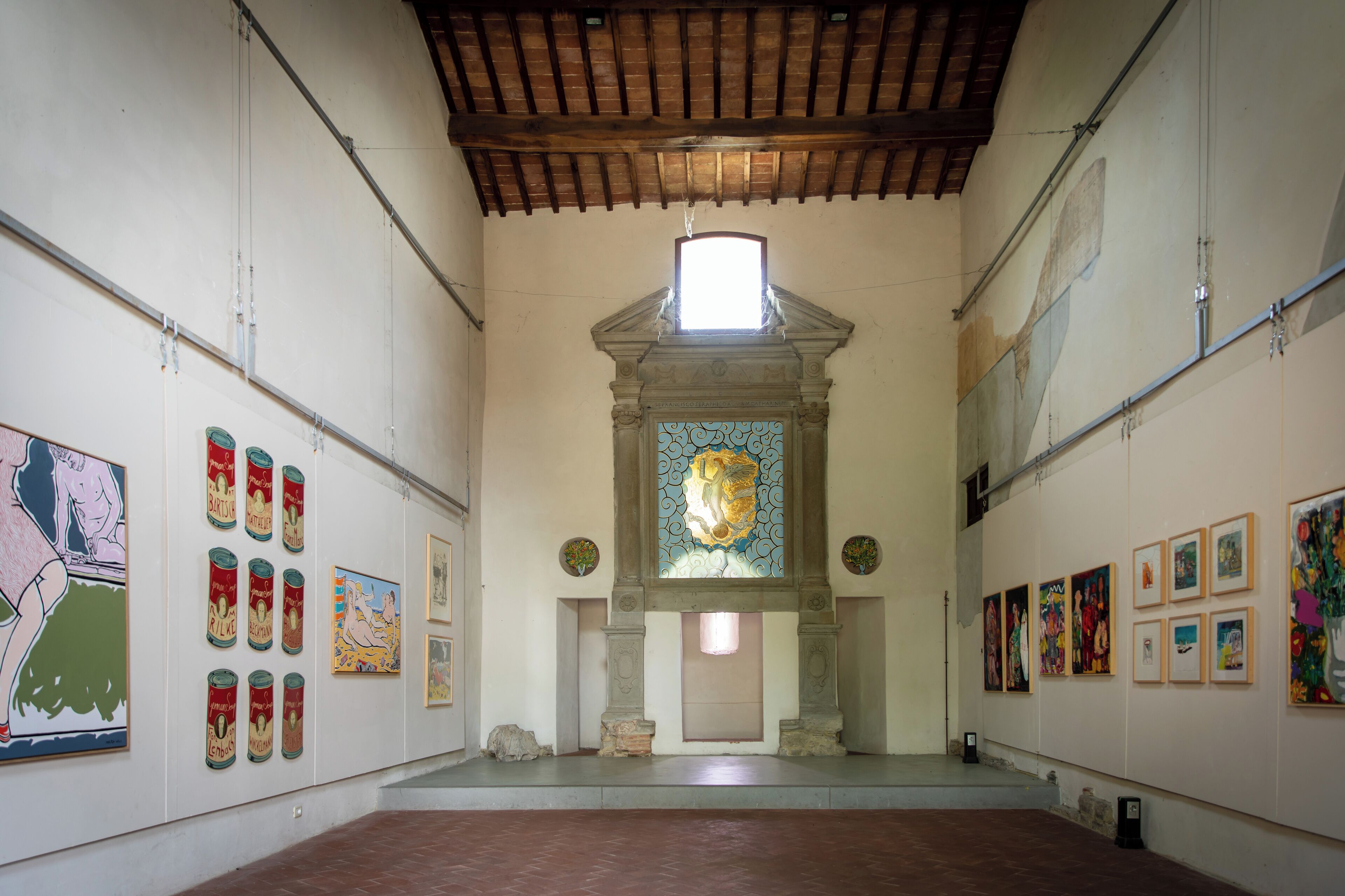 An art gallery with a high ceiling and a central stained glass window.