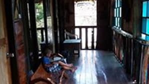 A wooden corridor with a bench, a window, and a door. - Kopi Doki Guest Haus (Coron)