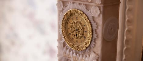 A close-up of a clock with ornate carvings and a golden face.