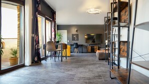 Una sala moderna con chimenea, un comedor con sillas y una estantería.