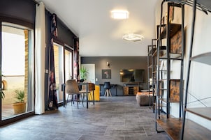 Una sala moderna con chimenea, un comedor con sillas y una estantería.