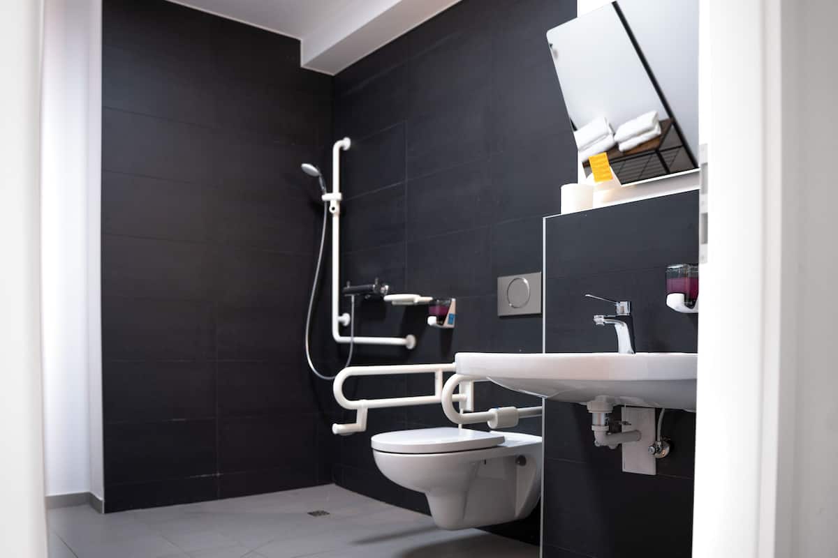 A modern bathroom with a toilet, sink, and shower.