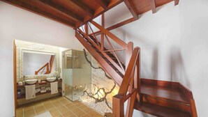 A bathroom with a wooden staircase, a large mirror, and a decorative wall. - Delmás Hotel Emblemático (Haria)