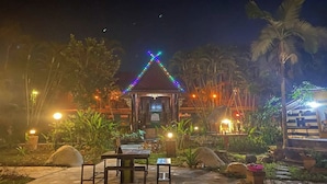 A gazebo with colorful lights, surrounded by tropical plants and palm trees. - Viewdoi Art and Resort by Zuzu (Chiang Mai)