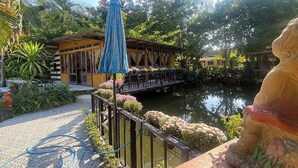 A serene outdoor area with a water feature, a covered seating area, and a statue. - Viewdoi Art and Resort by Zuzu (Chiang Mai)