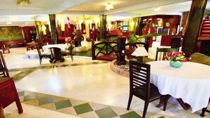 A spacious lobby with a checkered floor, multiple dining tables, and chairs, and a fountain in the center. - Viewdoi Art and Resort by Zuzu (Chiang Mai)