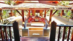 A covered outdoor seating area with a tiled roof, surrounded by plants and a wooden structure. - Viewdoi Art and Resort by Zuzu (Chiang Mai)