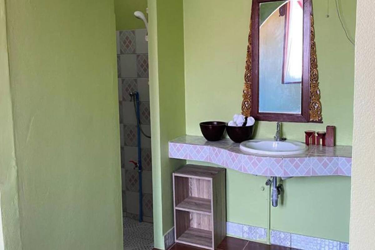 A bathroom with a sink, mirror, and two bowls on the counter.