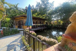 A serene outdoor area with a water feature, a covered seating area, and a statue. - Viewdoi Art and Resort by Zuzu (Chiang Mai)