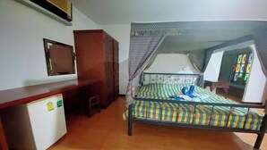 A bedroom with a bed, a desk, a small refrigerator, and a window with a view. - Viewdoi Art and Resort by Zuzu (Chiang Mai)