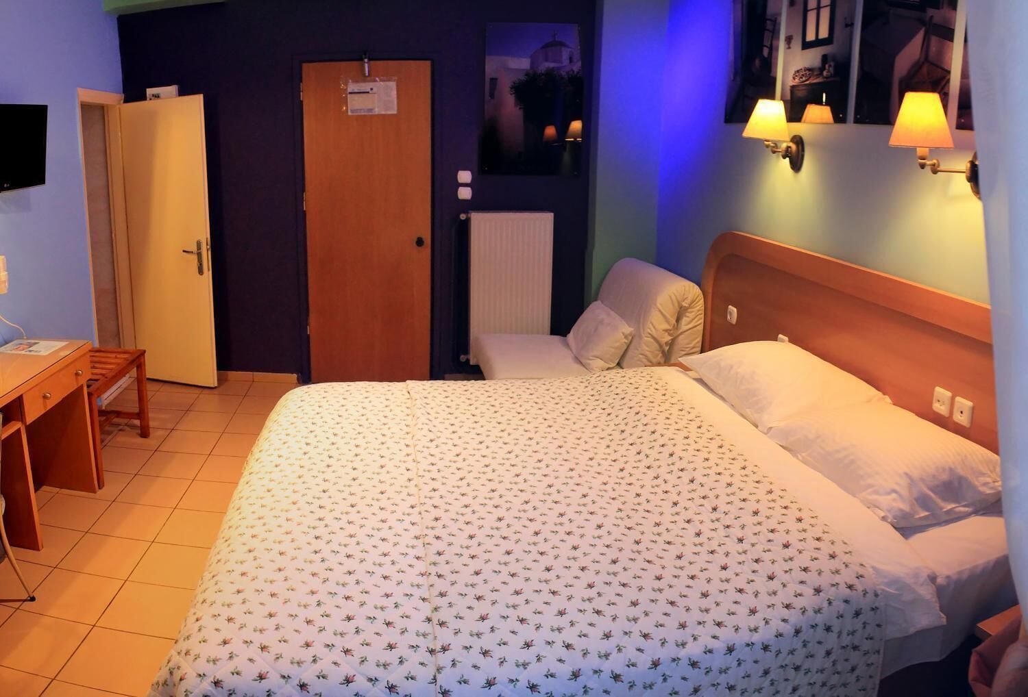Ein Hotelzimmer mit Bett, Schreibtisch, Stuhl, Kleiderschrank und Bad.