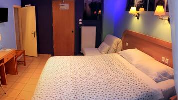 Ein Hotelzimmer mit Bett, Schreibtisch, Stuhl, Kleiderschrank und Bad.