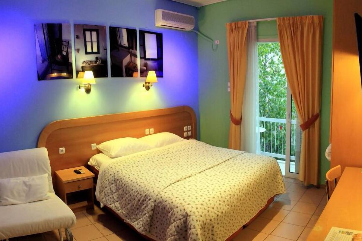 A bedroom with a bed, bedside tables, a chair, and a window with curtains.