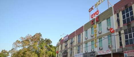 A hotel with multiple signs, including 'OYO HOTEL' and 'NOSTALGIA JAYA ENTERPRISE'.