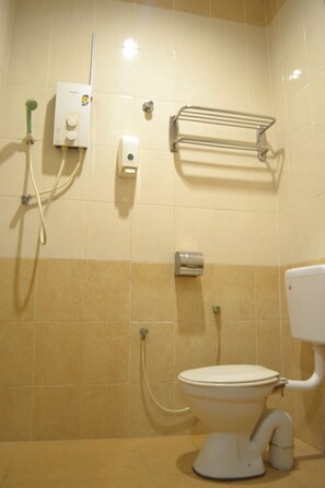 A bathroom with a toilet, a hand dryer, a towel rack, and a showerhead. - OYO 89715 CK Hotel 2 (Lumut)