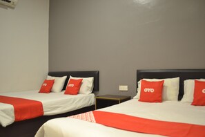 Two beds with red and white bedding, a grey wall, and a small wooden nightstand between them. - OYO 89715 CK Hotel 2 (Lumut)