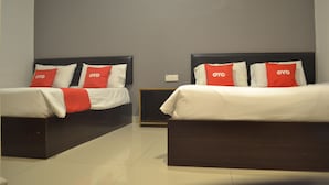 A hotel room with two beds, each with a black headboard and red and white bedding. - OYO 89715 CK Hotel 2 (Lumut)