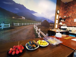 Una mesa con fruta y un interior rústico con vistas a la montaña.