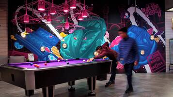 A pool table in a room with a mural on the wall.