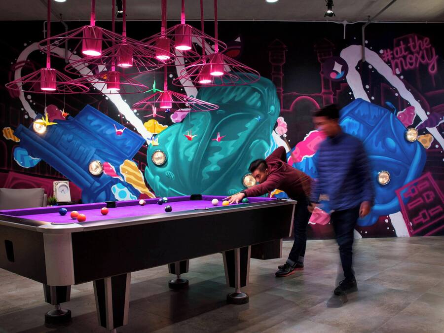 A pool table in a room with a mural on the wall.