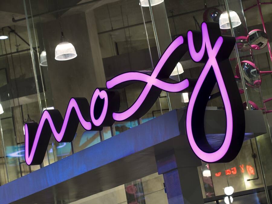 A neon sign with the word "moXy" in a stylized font.