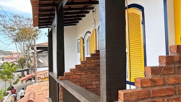 A hotel with a covered outdoor area, brick walls, and yellow doors. - Pousada Aldeia Buzios (Búzios)