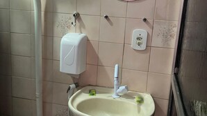 A bathroom with a toilet, sink, and a mirror.