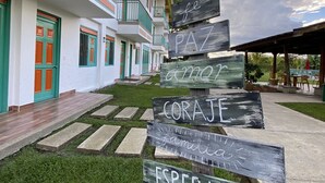 Un edificio con varios balcones y un cartel con indicaciones de madera.