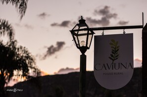 A sign for CAVIUNA POUSO RURAL with a lantern and a logo.
