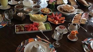 Un bufé de desayuno con diversos platos, como frutas, pan y bebidas.