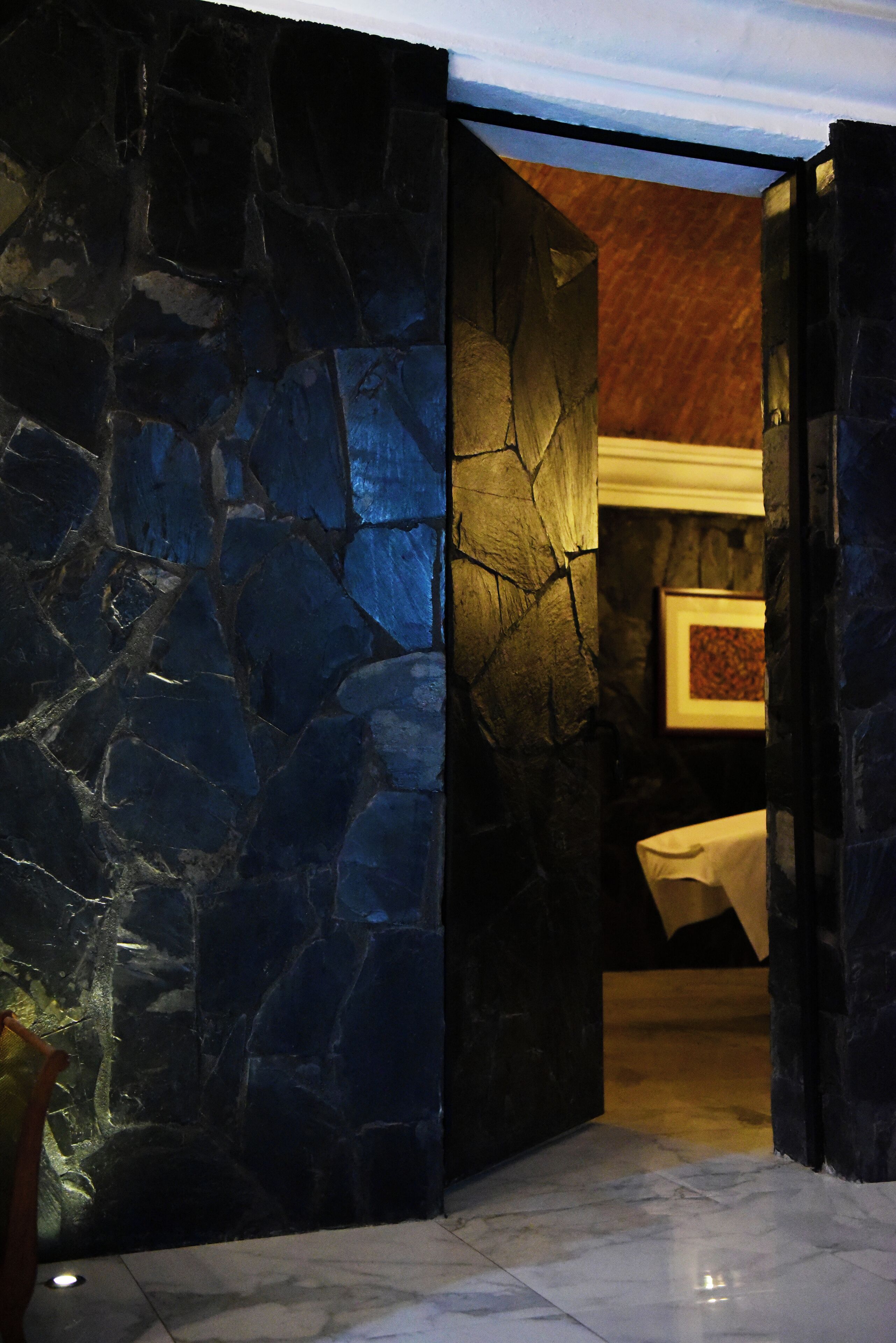 A stone wall with a framed picture on the wall.