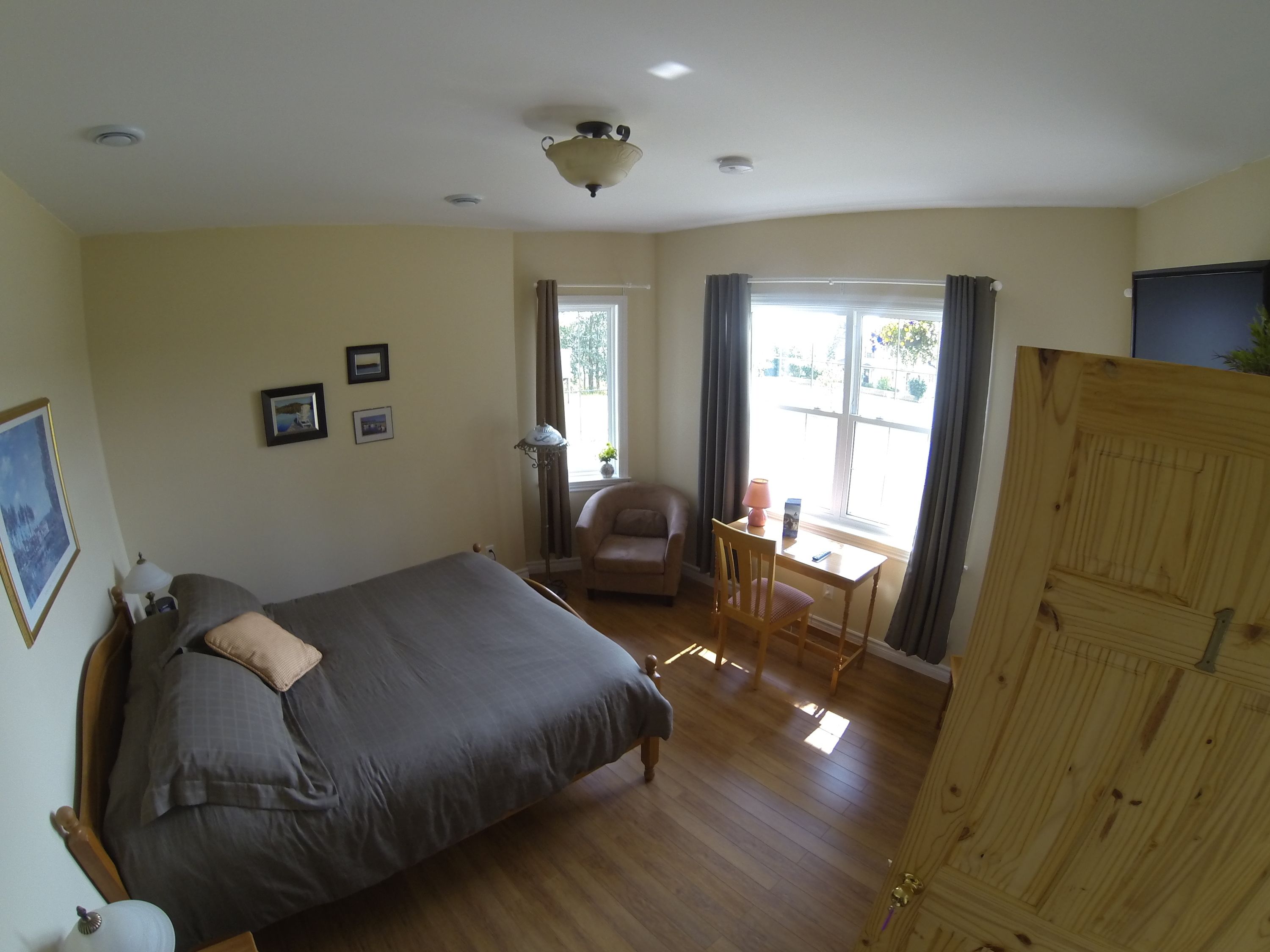 Un dormitorio con cama, una silla, una mesita y un armario.