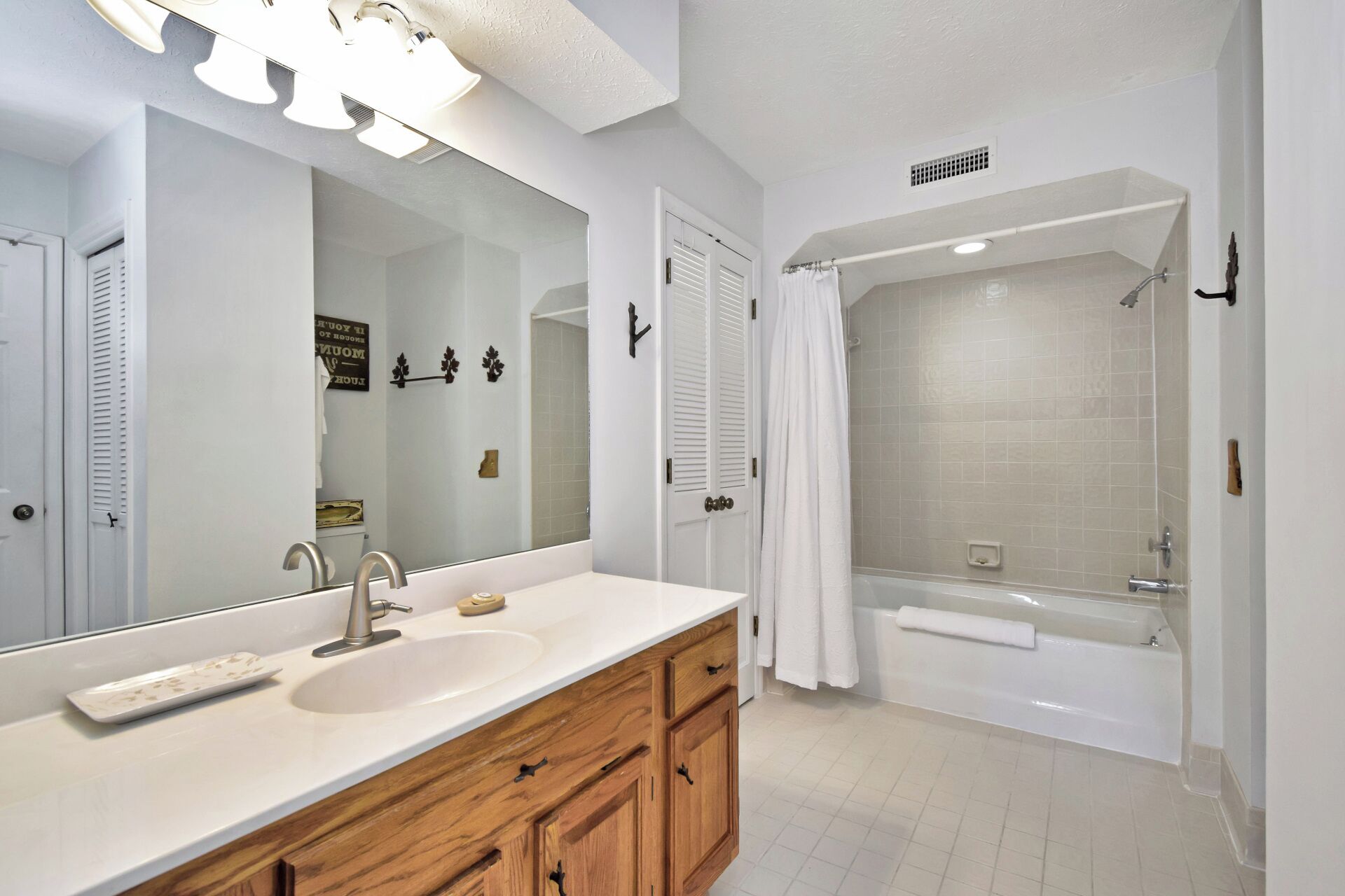 Une salle de bain moderne avec un grand miroir, un lavabo, des meubles en bois, une douche et une baignoire.