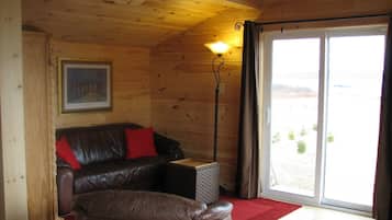 Romantische chalet, 1 slaapkamer, uitzicht op zee, aan zee | Woonkamer | Televisie, een open haard en een dvd-speler