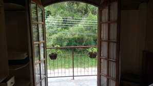 An open balcony with a view of a green garden. - Hotel Vill' Agi (Campos do Jordão)