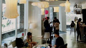 A spacious lobby with modern pendant lighting, comfortable seating areas, and large windows offering views of the street. - Single Inn Kaohsiung Station Hostel (Kaohsiung)