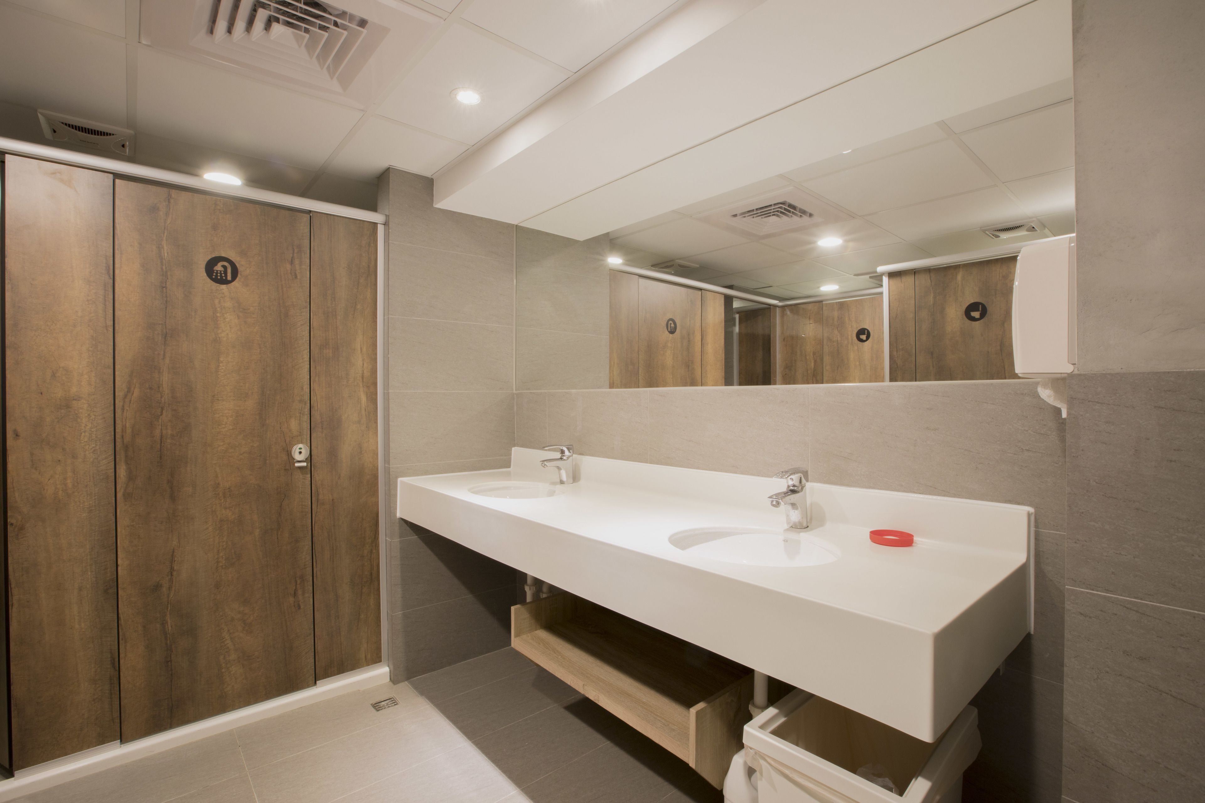 Une salle de bain moderne avec deux vasques, des meubles en bois et un grand miroir.