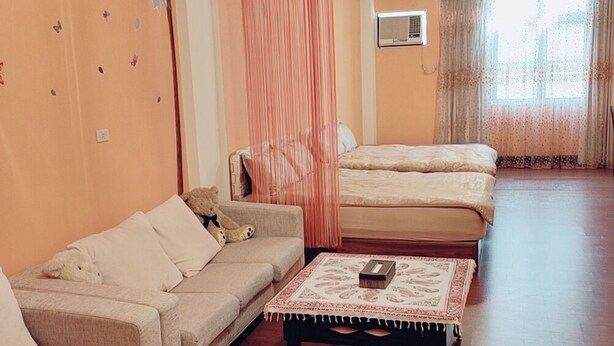 A room with a sofa, a bed, a table, and a curtain. - Tainan Here Hostel (Tainan)