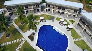 Un hôtel moderne doté d’une piscine centrale, de nombreux balcons et d’espaces de détente en plein air.
