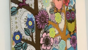 A wall decoration featuring a tree with colorful owls and flowers. - Tainan Here Hostel 2 (Tainan)