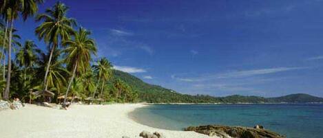 In Strandnähe, weißer Sandstrand, Liegestühle, Sonnenschirme