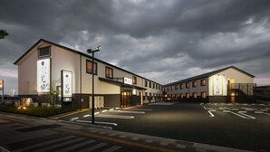 Un bâtiment moderne, doté d’une grande enseigne, d’un parking et d’une entrée sécurisée par un portail.