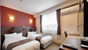 Une chambre d’hôtel avec deux lits, un bureau, une chaise, une télévision et un appareil de climatisation.