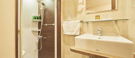 A bathroom with a shower, a sink, a mirror, and a towel rack.