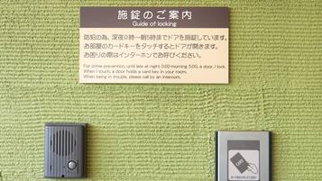 A guide of locking instructions on a green textured wall, a door lock, and a card reader.
