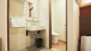 A compact bathroom with a sink, mirror, towel rack, and toilet.