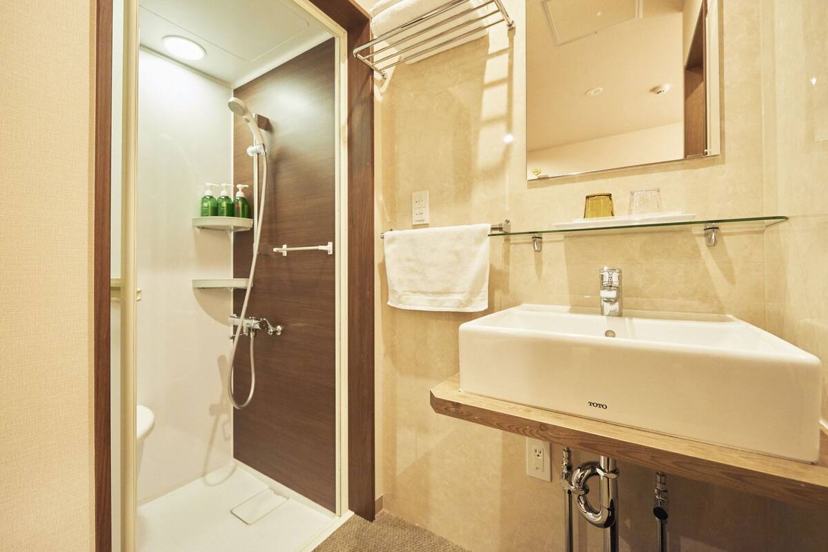 A bathroom with a shower, a sink, and a mirror.
